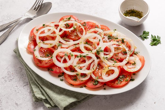 Serving Dish With Sliced Onions, Tomatoes And Seasoning