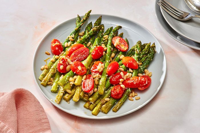 Baked asparagus and tomatoes on a serving plate