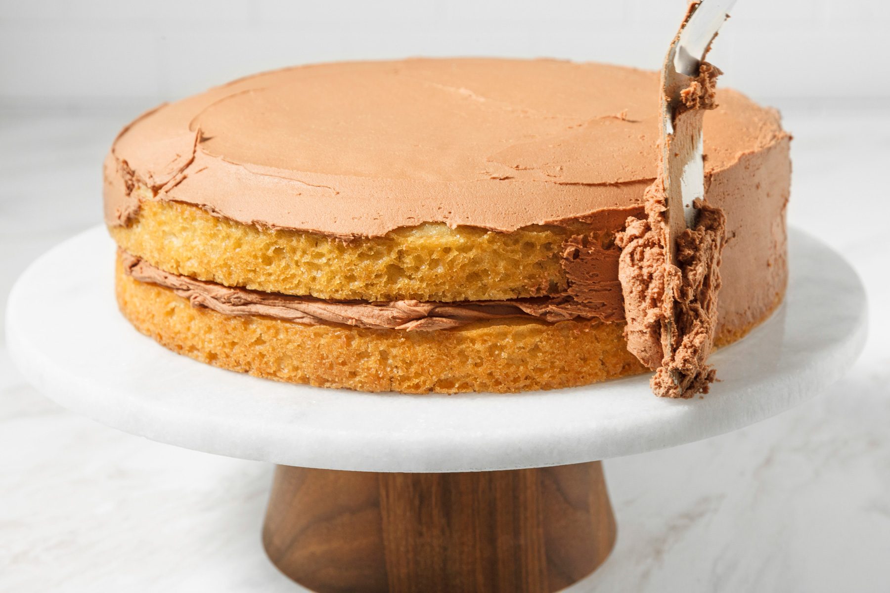 Top and sides of a two-layer cake being frosted.
