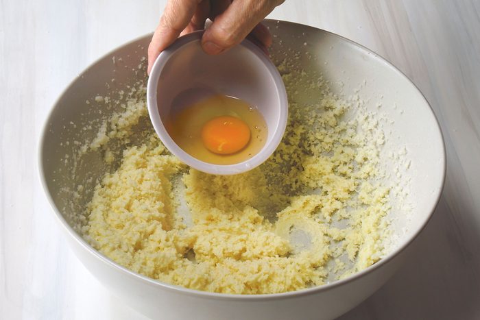 Adding eggs to butter and sugar mixture