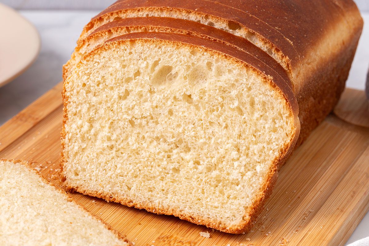 Sliced Country White Bread on a wooden cutting board for Taste of Home