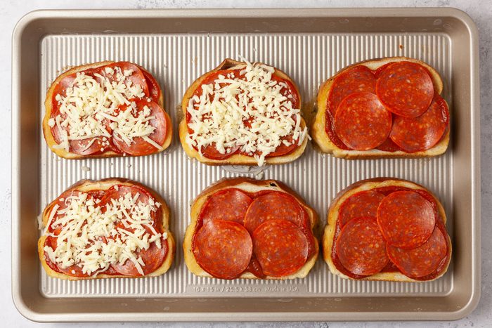 Step 2 of Taste of Home Garlic Bread Pizza is to top with sauce, cheese and pepperoni