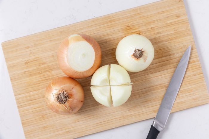 Onions being prepared cut in quarters.