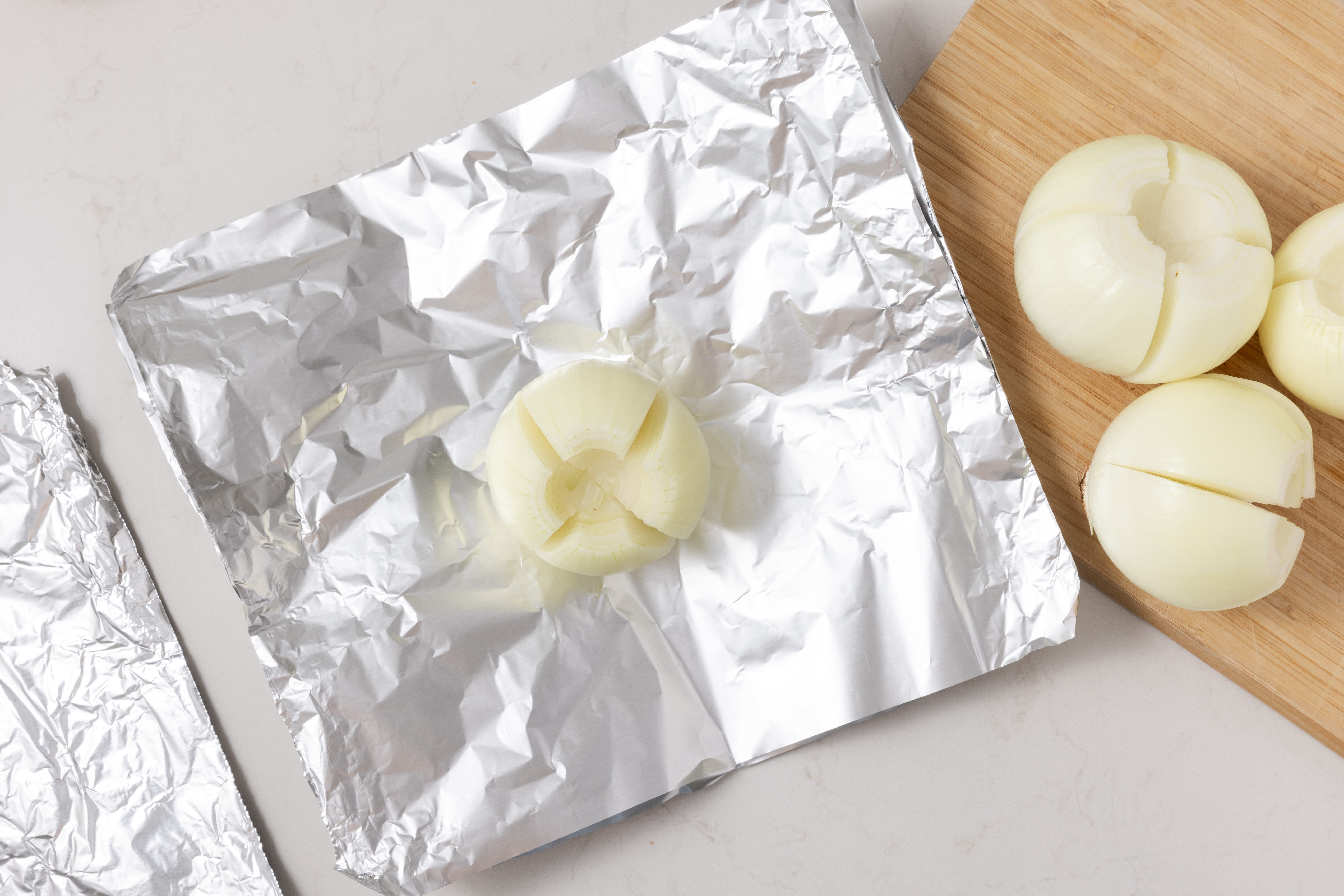 Onions being placed on heavy-duty foil.