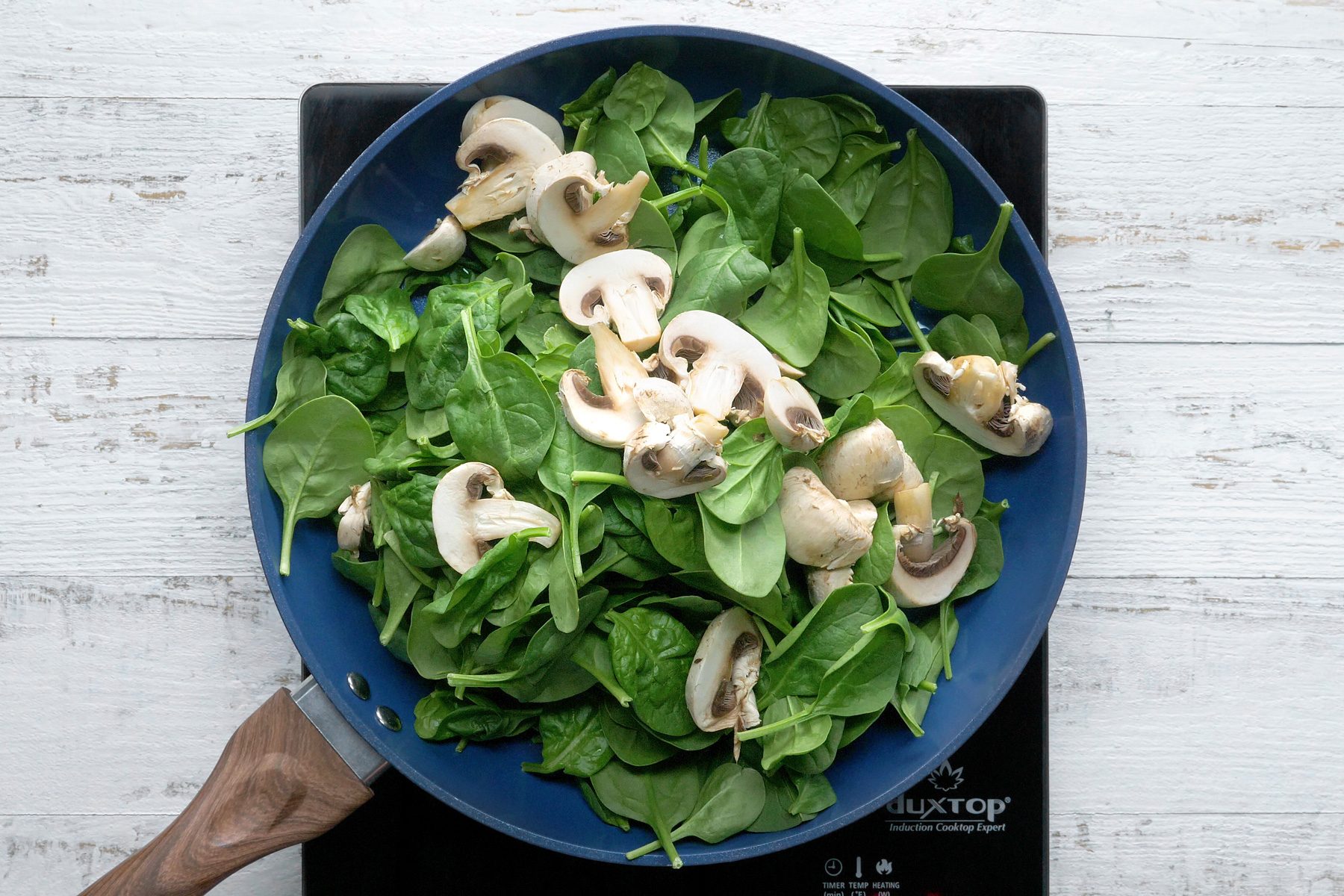 In a large skillet, heat oil over medium-high heat. Add spinach and mushrooms; cook