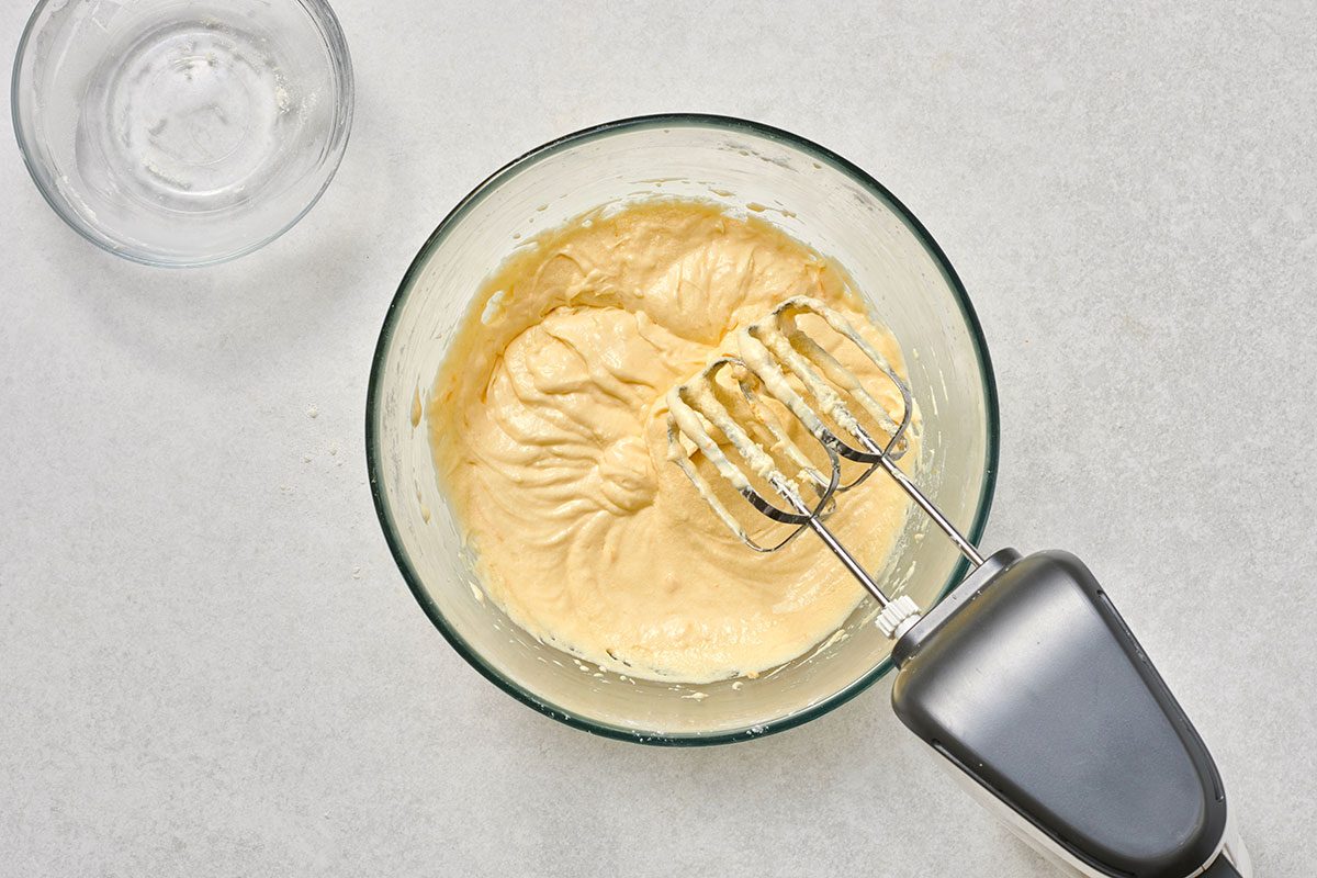 Dry ingredients added to the creamed mixture, ready to be gently mixed until combined.