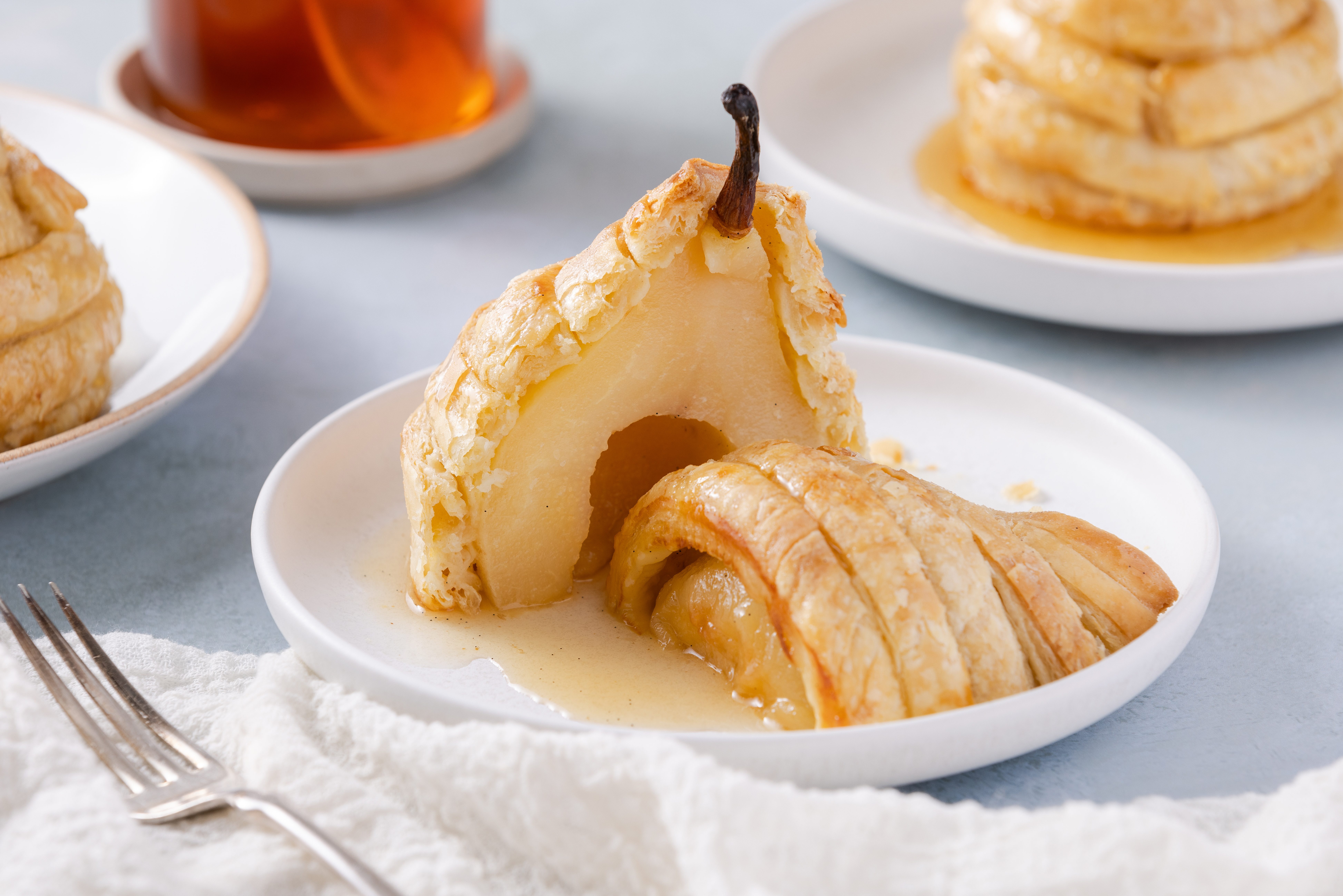 Pears puff pastry served on small plate and cut in half showing inside.