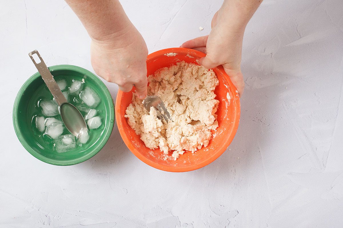 Adding ice water to clour and butter