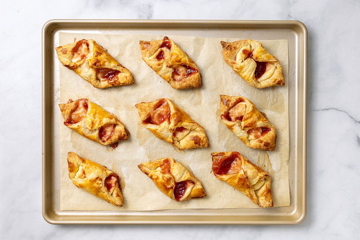 Baked Puff Pastry Danishes on a baking sheet for step four of Puff Pastry Danish recipe for Taste of Home