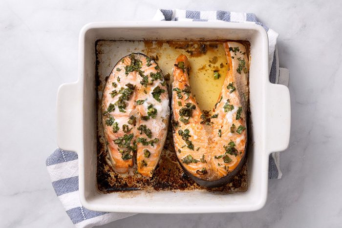 Baked Salmon Steaks in a baking dish for step four of Salmon Steak recipe for Taste of Home