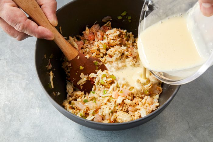 Adding milk to seafood mixture