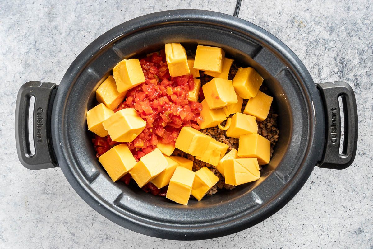 Taste of Home Slow Cooker Cheese Dip photo of the cheese and tomatoes added to the slow cooker.