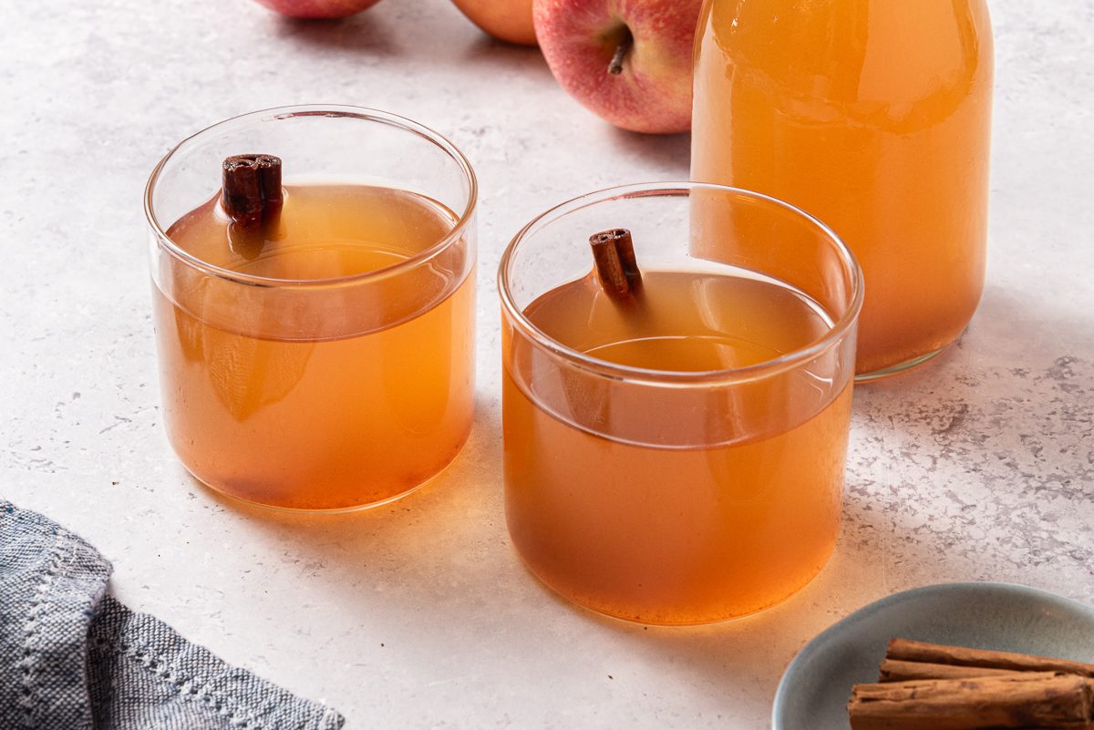 Spiced Apple Cider Inside Glasses With Cinnamon Sticks