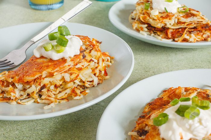 Stuffed Hash browns plated with sour cream and green onions