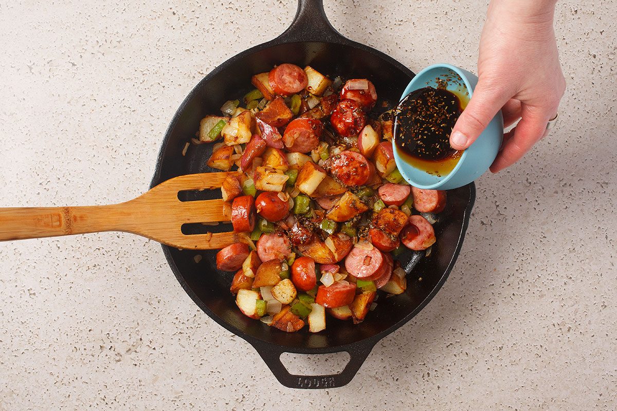 Brats And Potatoes And Veggies Cooking In Skillet