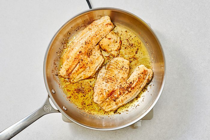 Cooked tilapia fillets in a large skillet