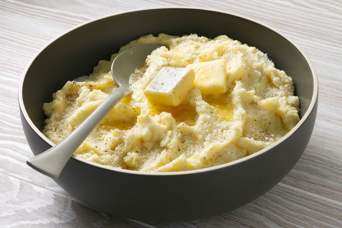 Table view shot of Truffle Mashed Potatoes; stir in remaining 1 teaspoon salt and pepper; sprinkle with truffle salt and additional Parmesan and pepper before serving; spoon; wooden surface;