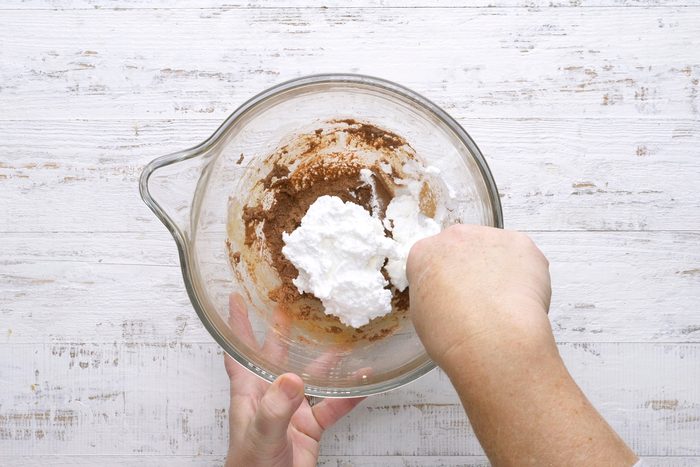 Gradually adding the sifted dry ingredients to the yolk mixture and mixing well.