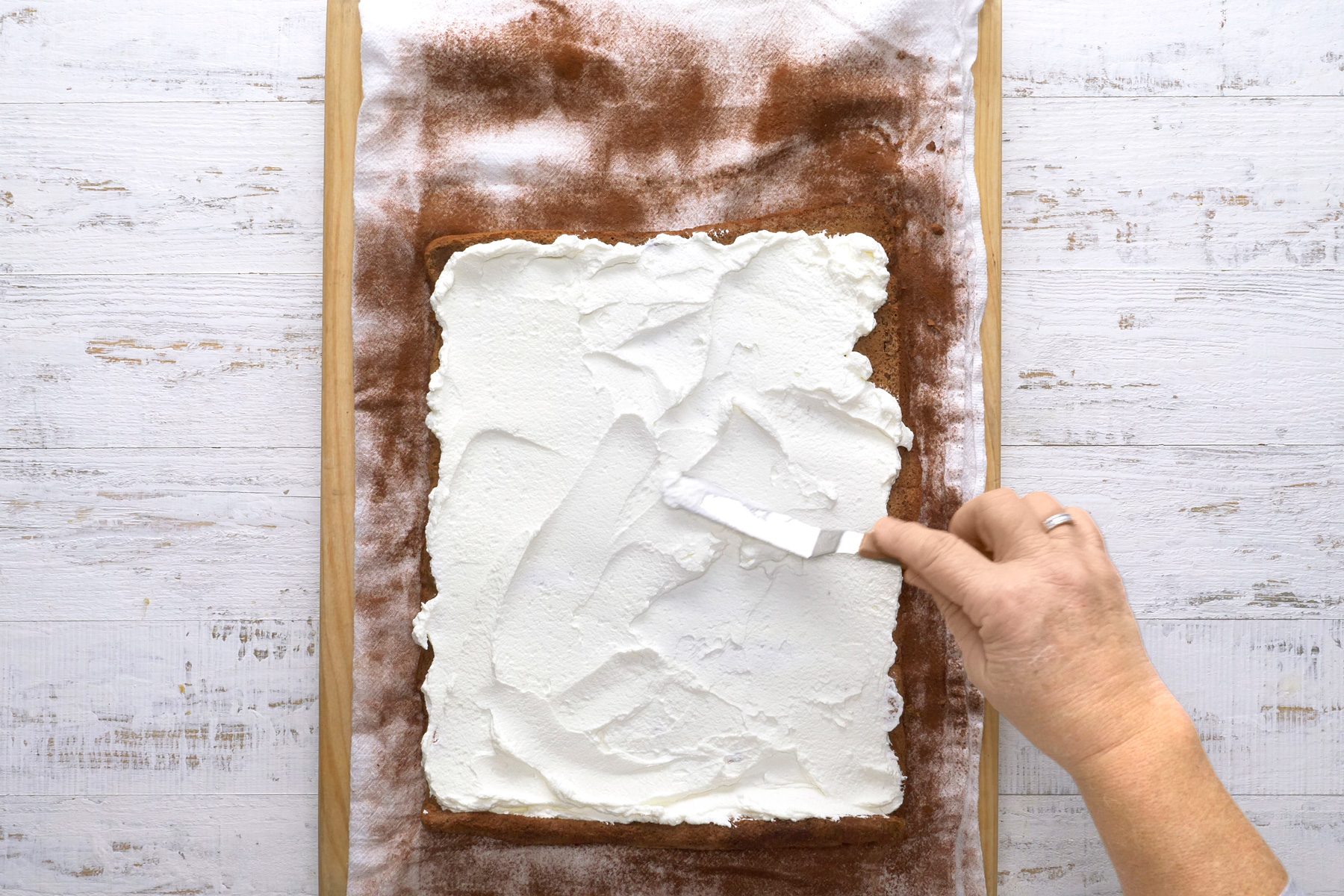 Frosting the cake with a metal spatula.