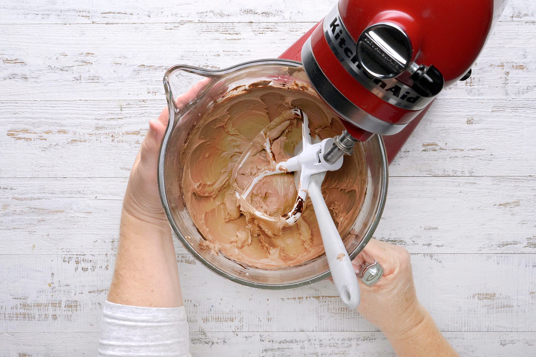 Beating in chocolate, milk, and vanilla until the mixture is smooth.