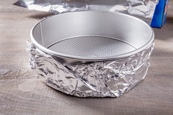 A springform pan wrapped in aluminium sheet layers