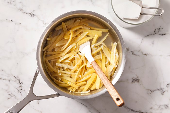 Place peel in a large heavy saucepan and cover with cold water, bring to a boil.