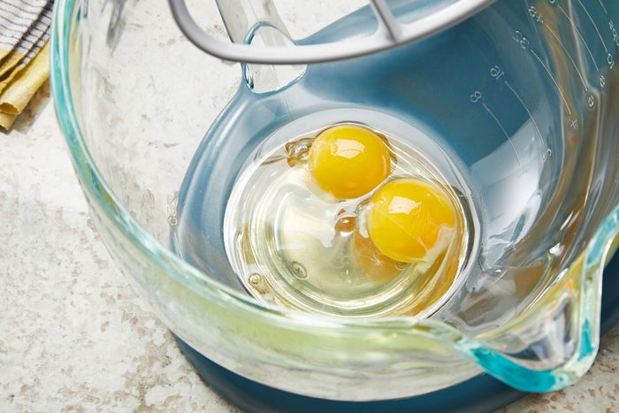 Beating eggs in a large glass bowl
