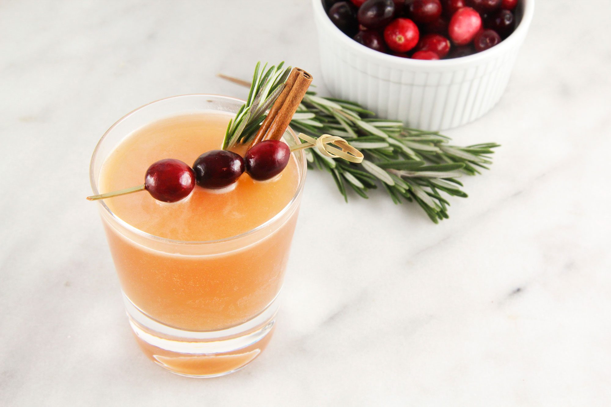 Naughty But Nice Cocktail served with a sprig of rosemary and cinnamon stick