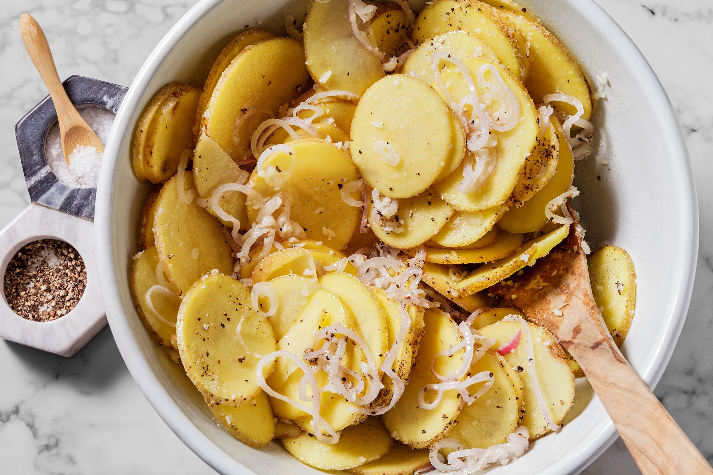 Potato slices, shallots and seasonings in a large bowl