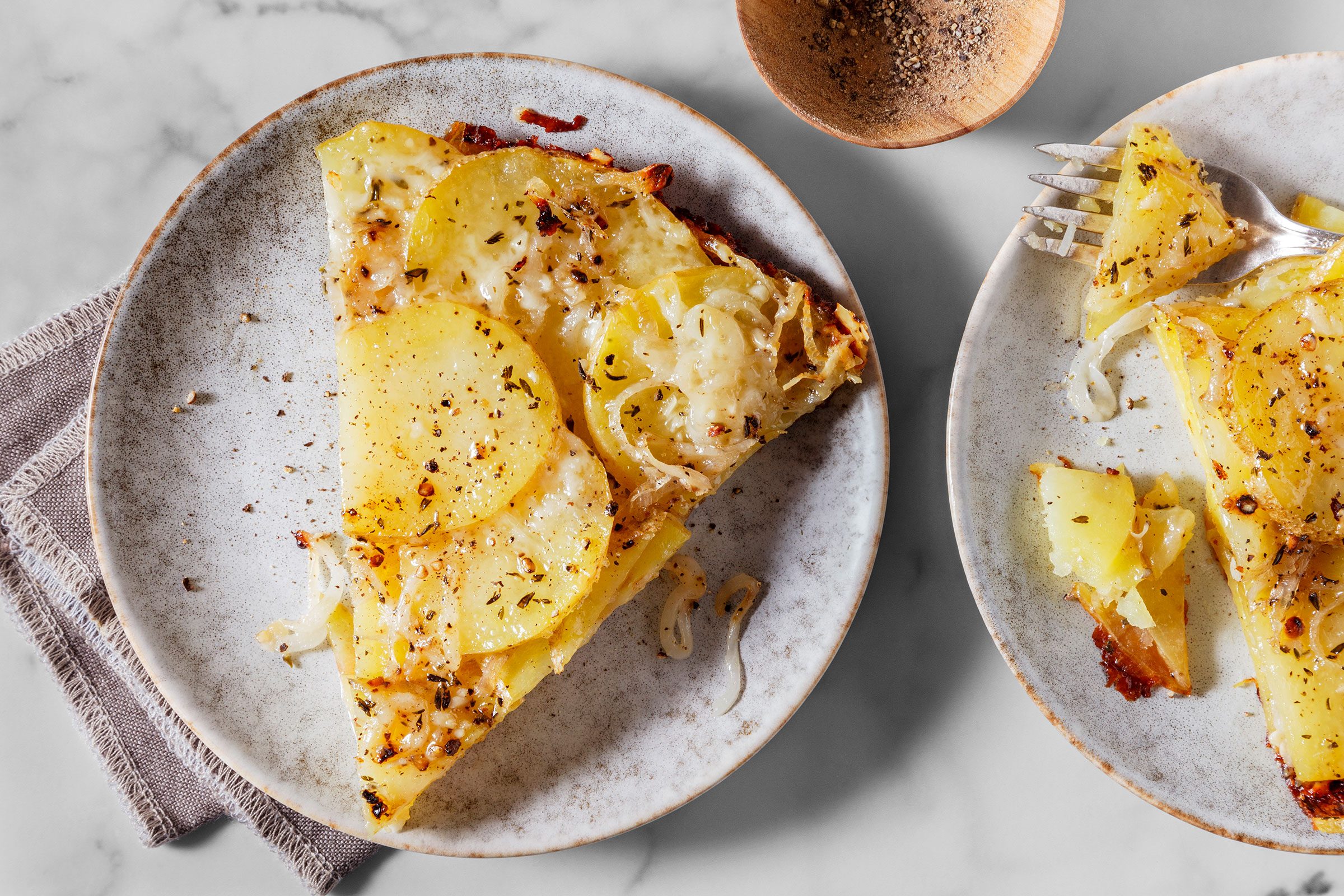 Baked potato galette sliced into wedges and served on a plate