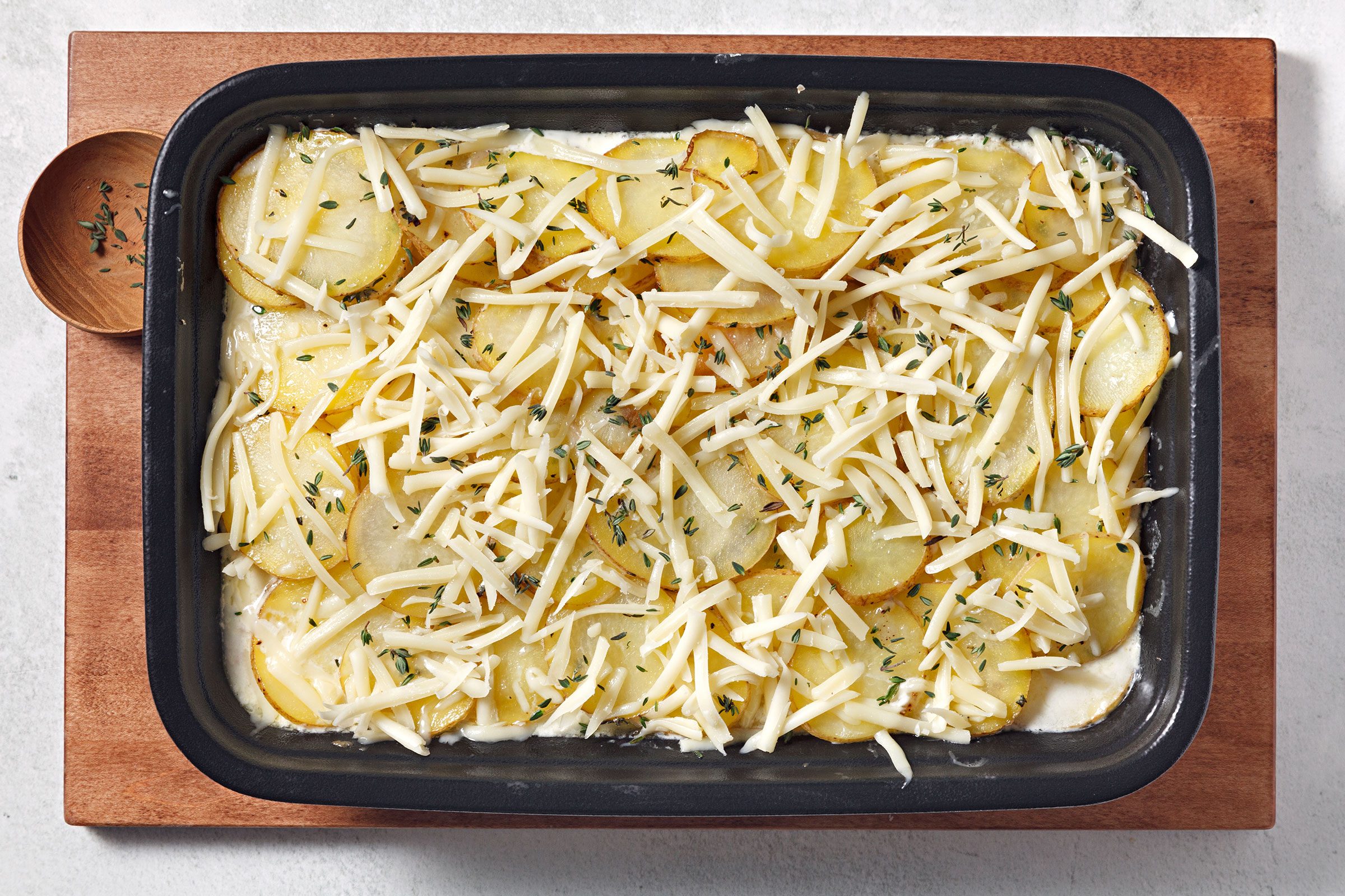 Grated Gruyere cheese and thyme sprinkled on casserole