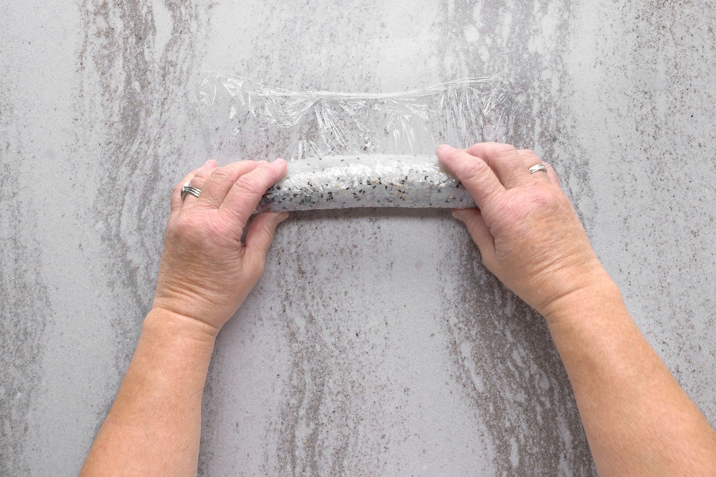 Shrimp Tempura Roll on a plastic wrap with sesame seeds on it