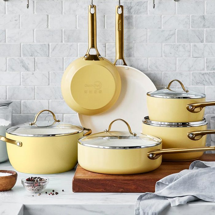 Four pots and two pans on a wooden and tile kitchen background