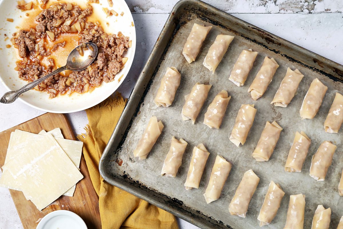 wontons coated with cooking spray on a baking sheet