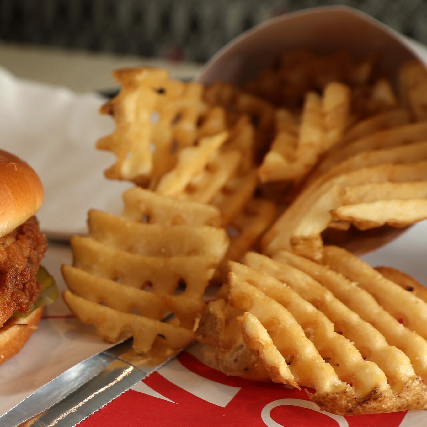 Chick-fil-A waffle fries with part of a chicken sandwich to the left