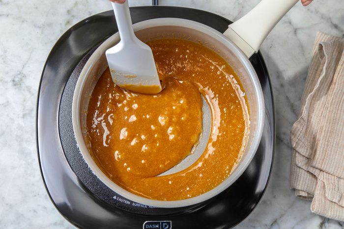 Cooking brown sugar, milk and butter in a saucepan and stirring with a ladle