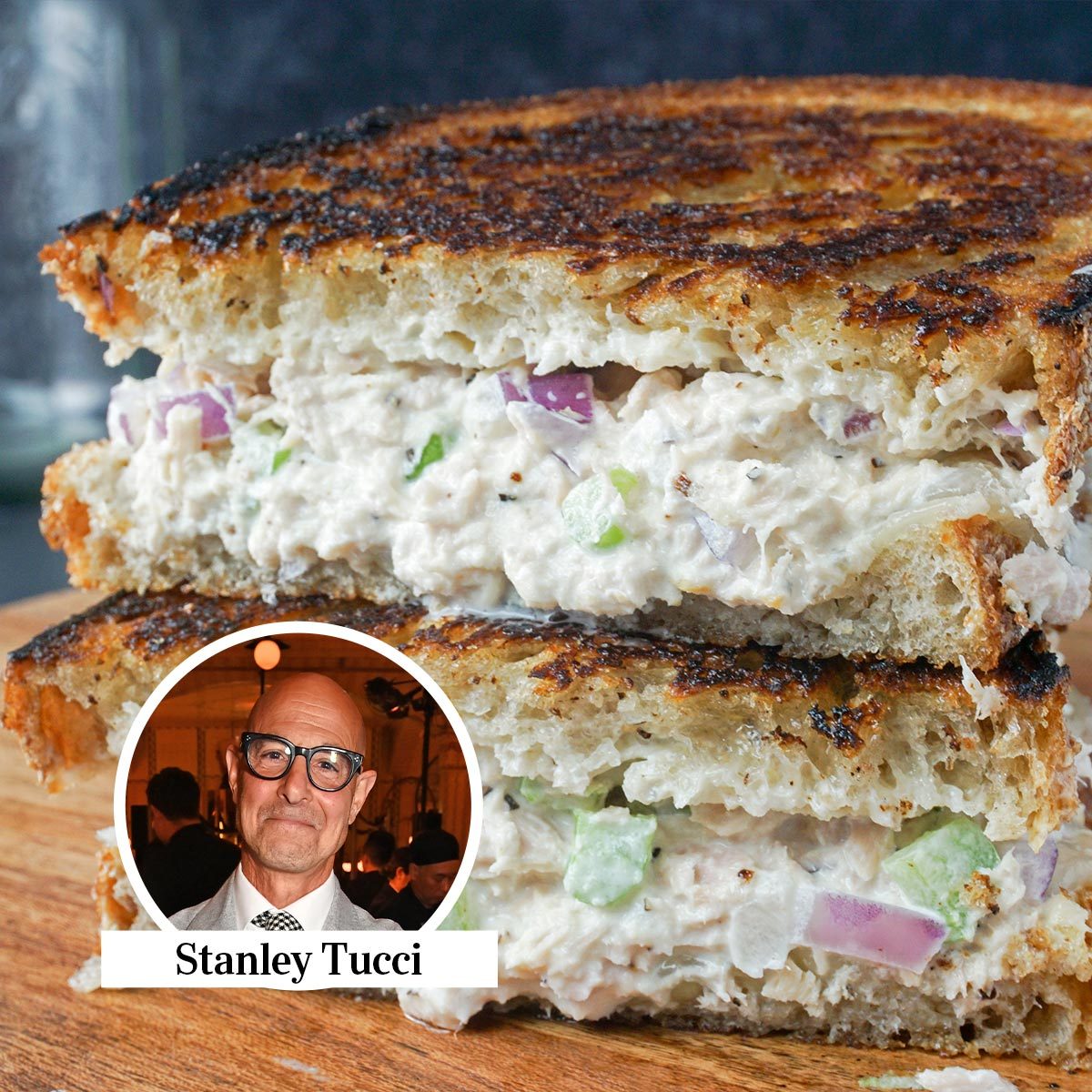 Tuna melt cut in half on a wooden cutting board with an inset headshot of Stanley Tucci on the bottom left