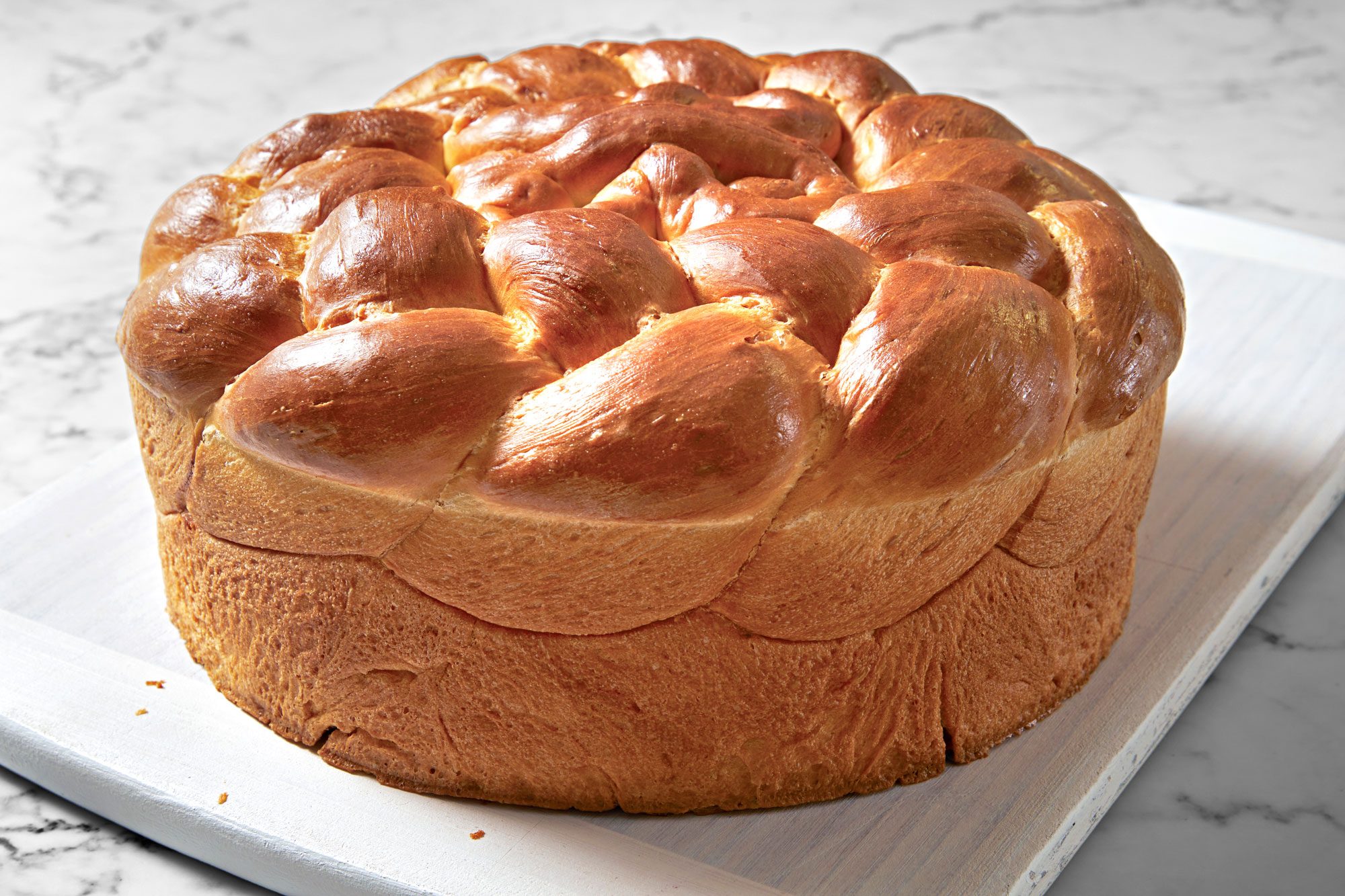Table view shot of Paska Easter Bread; serve on wooden tray; marble surface