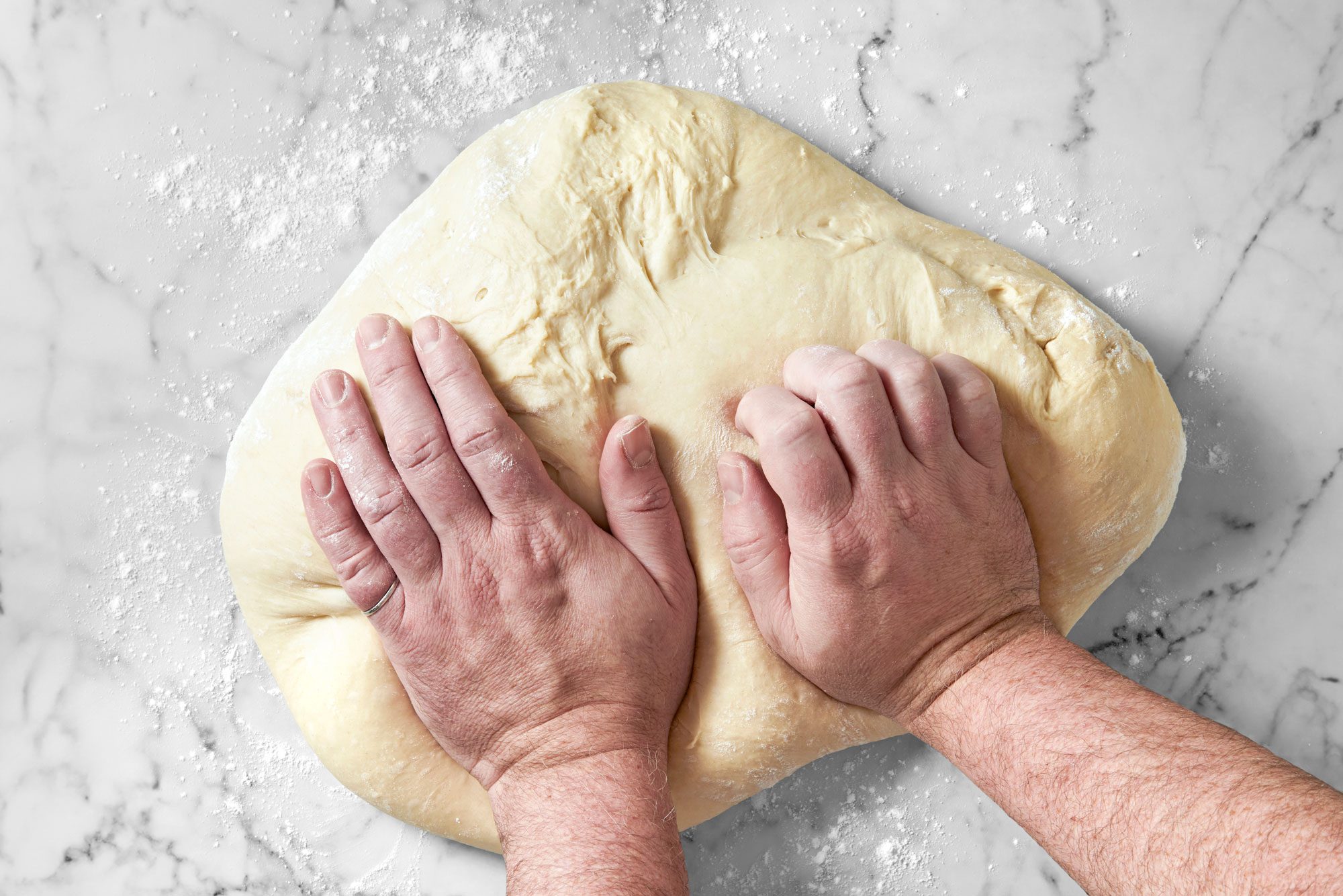 Overhaed shot of turn out onto a floured surface; knead until smooth and elastic 8-10 minutes; marble surface