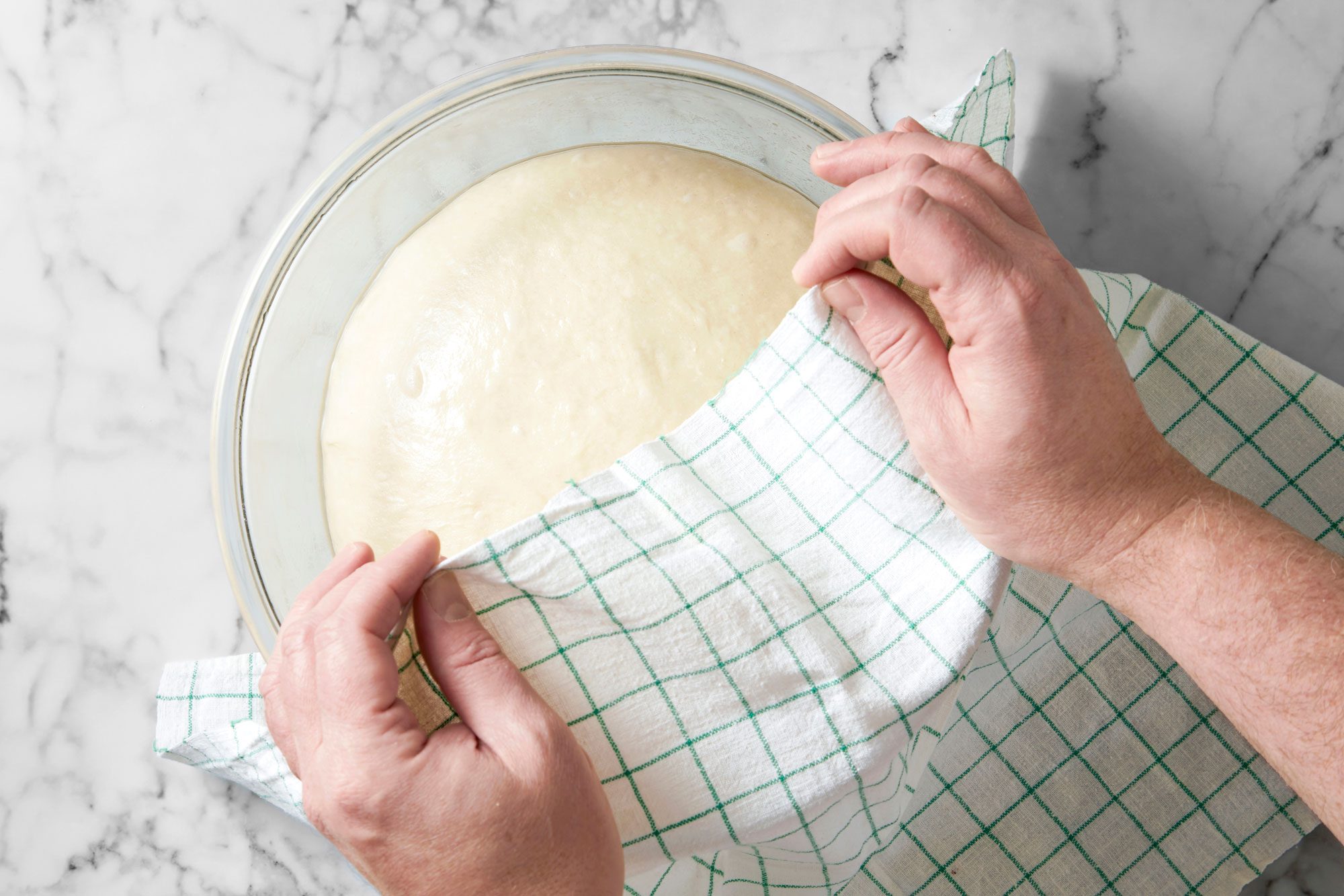 Overhead shot of place in a greased bowl; turning once to grease top; cover and let rise in a warm place until doubled about 1 hour; marble surface